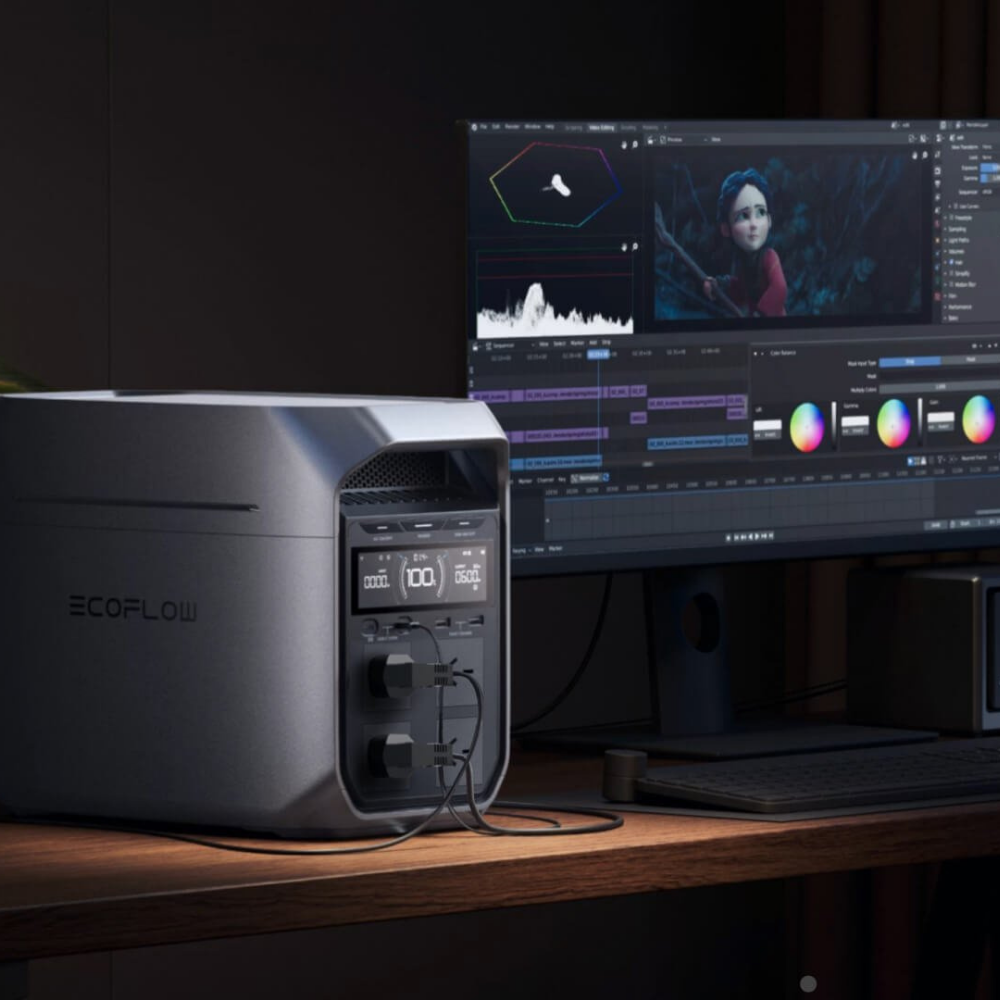 EcoFlow power station on a desk with a computer monitor displaying video editing software.