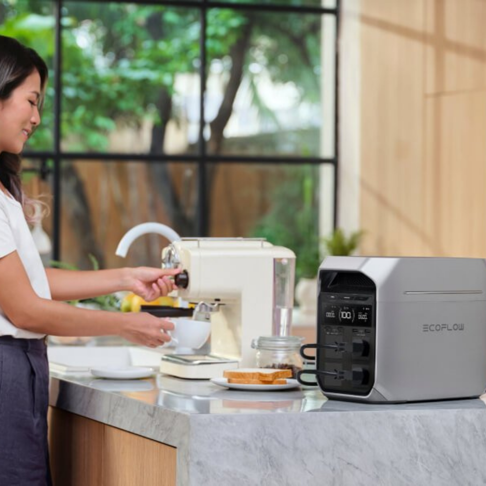 Woman preparing a drink at a kitchen counter with an EcoFlow device in the background