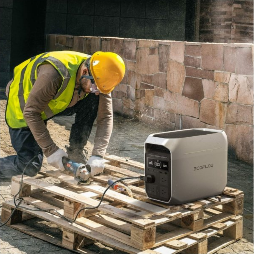 Person using a power tool next to a SCOPFLOW portable power station on a wooden pallet.