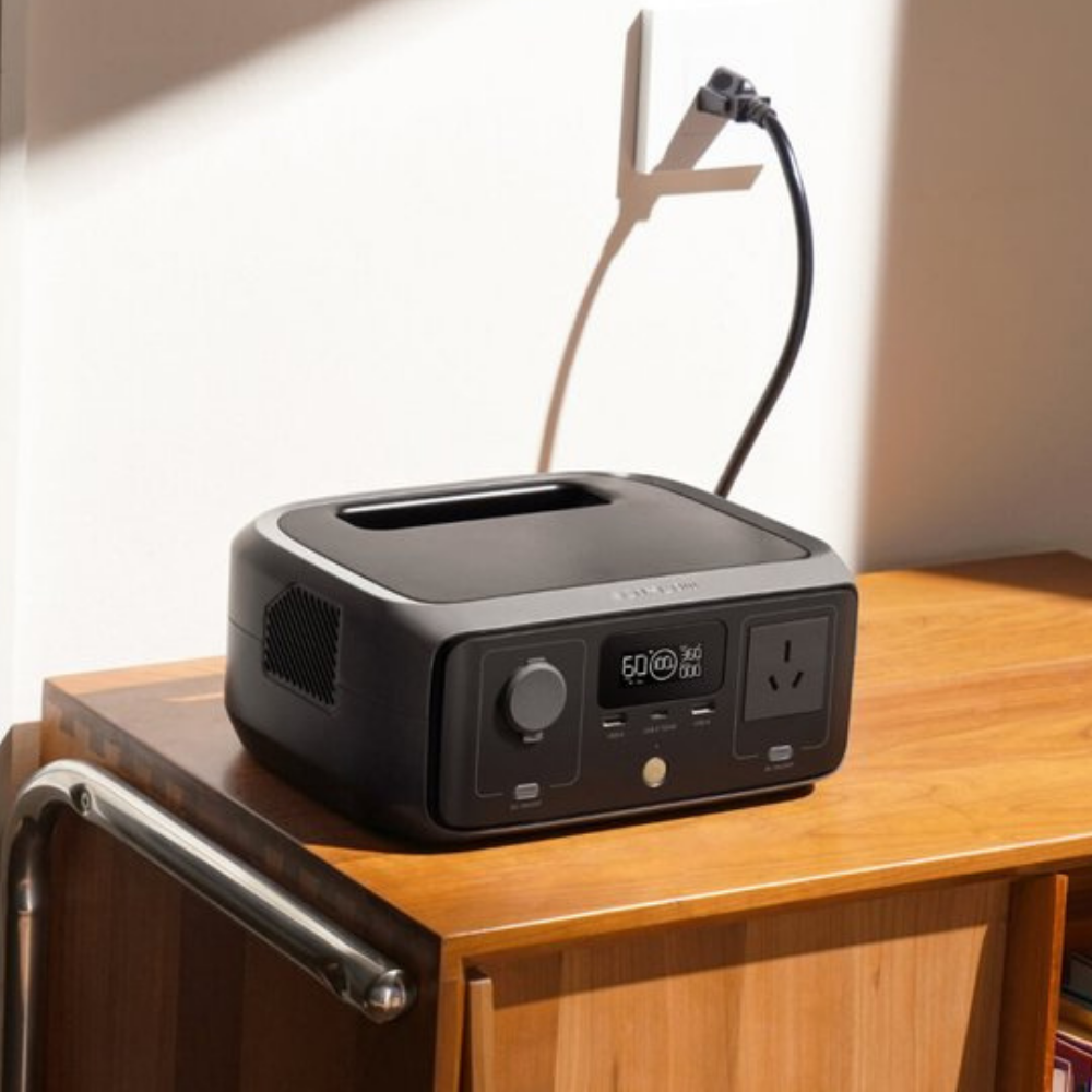 Black power station with multiple outlets and display on a wooden surface