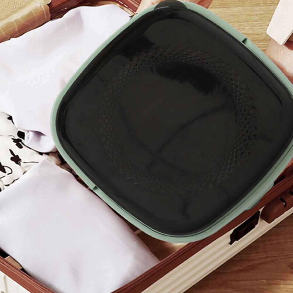 Top view of the mini washer in use, showing dark fabric inside the open washing machine on a laundry setup.