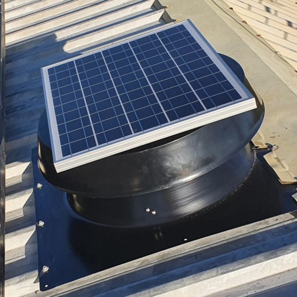 Black solar ventilator with a panel installed on a light corrugated metal roof.