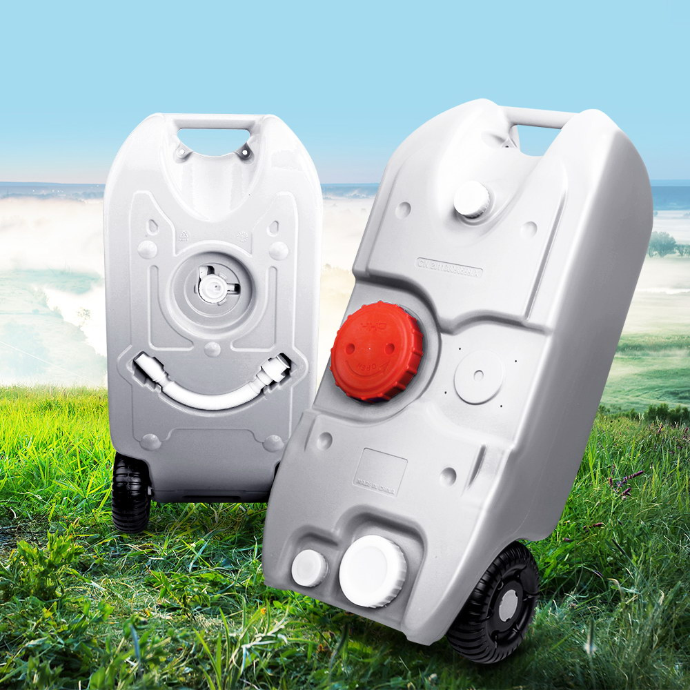 Two portable grey water tanks shown side by side on grass with a coastal background.