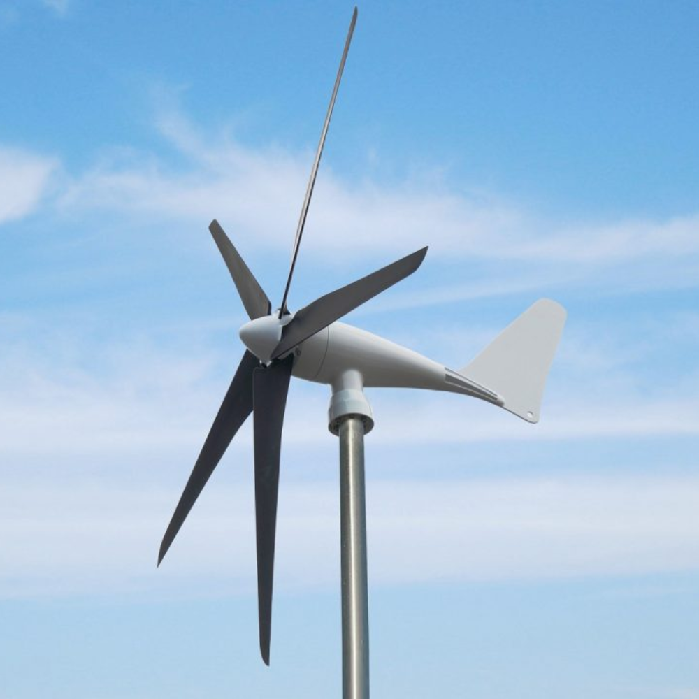 Tall pole-mounted wind turbine turning in the breeze under a bright blue sky.
