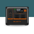Front-facing view of the Bluetti portable power station with illuminated LCD display and dual AC outlets against a two-tone blue and white background.