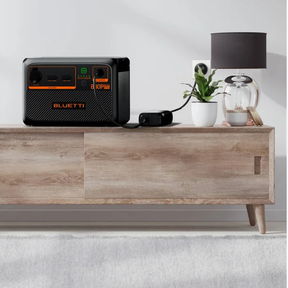 Bluetti unit placed on a wooden side table, next to a plant and lamp, for indoor backup scenario.