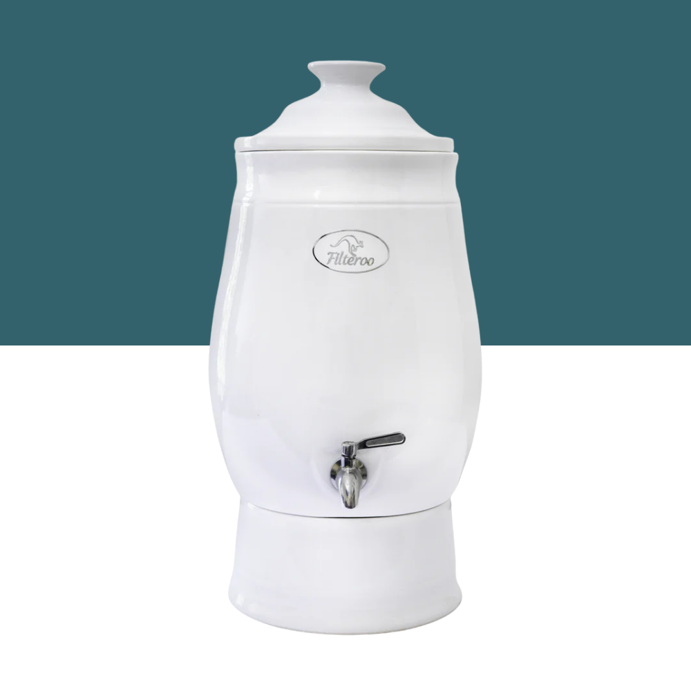 White ceramic water dispenser with a silver faucet on a white background