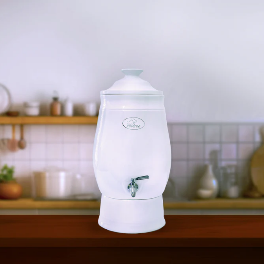 White ceramic water dispenser on a kitchen counter with a blurred background