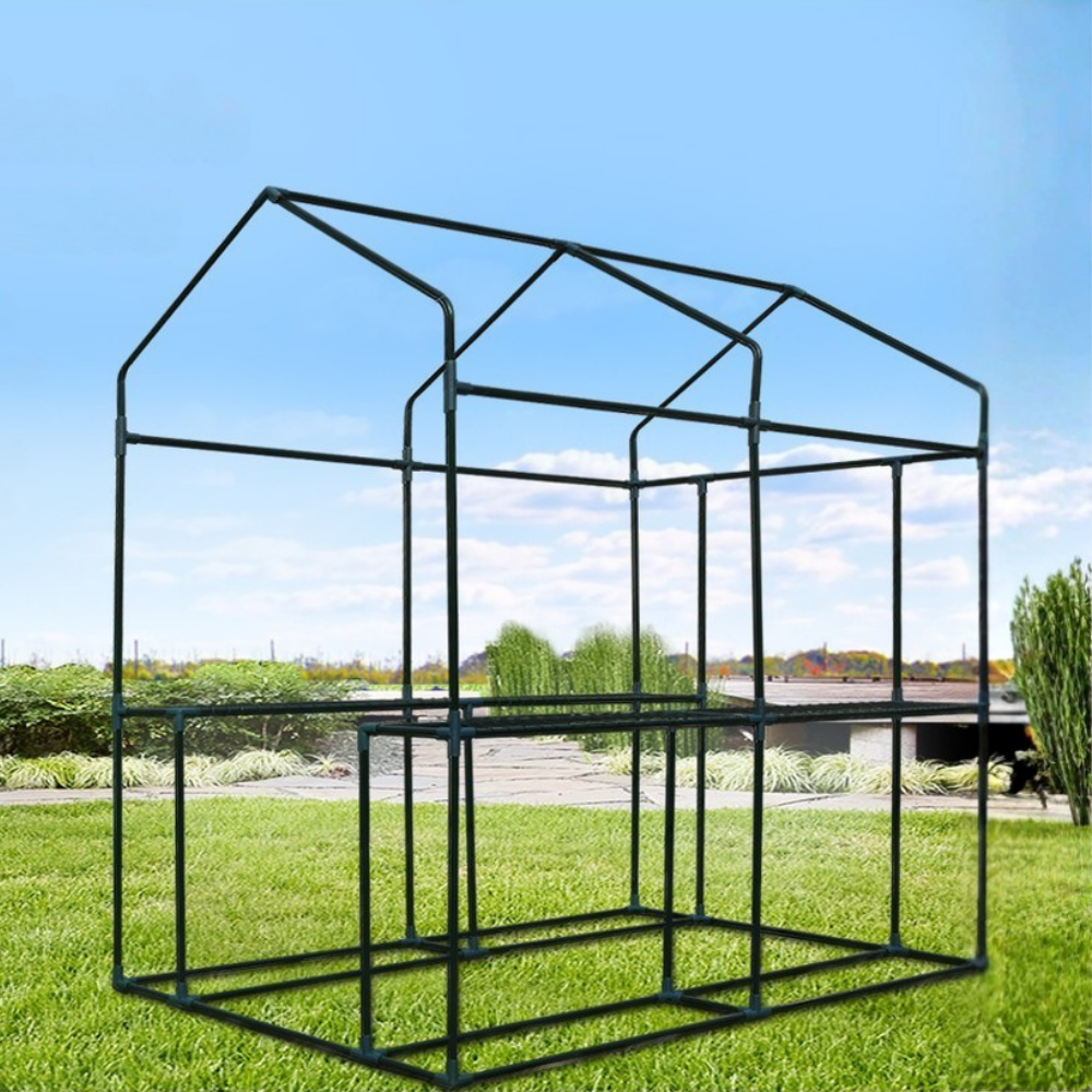 Metal greenhouse frame on grass with a clear blue sky