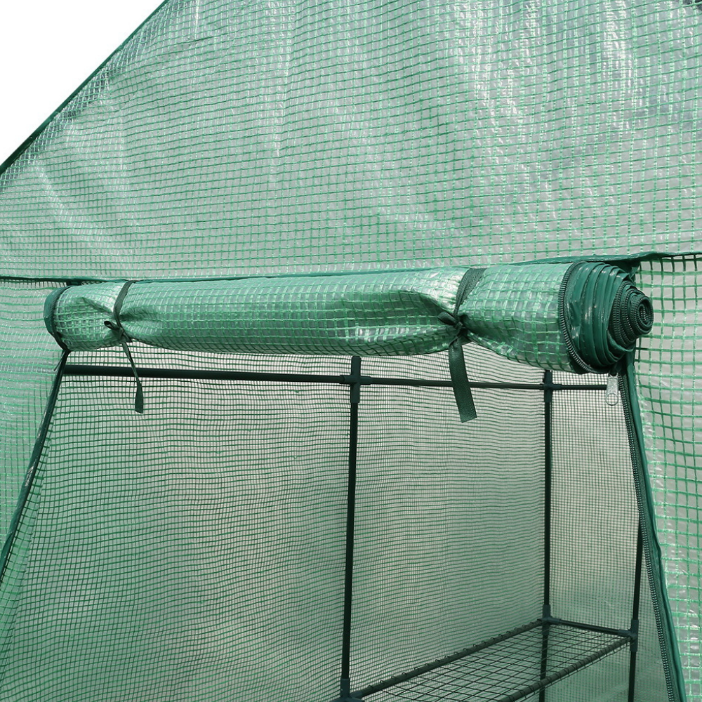 Green mesh tent with a roll of green mesh on top, used for gardening or outdoor projects.