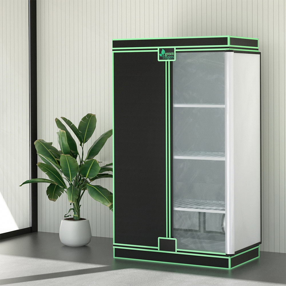 A Green Fingers hydroponic grow tent with black and neon green trim features shelving and sits next to a potted plant.