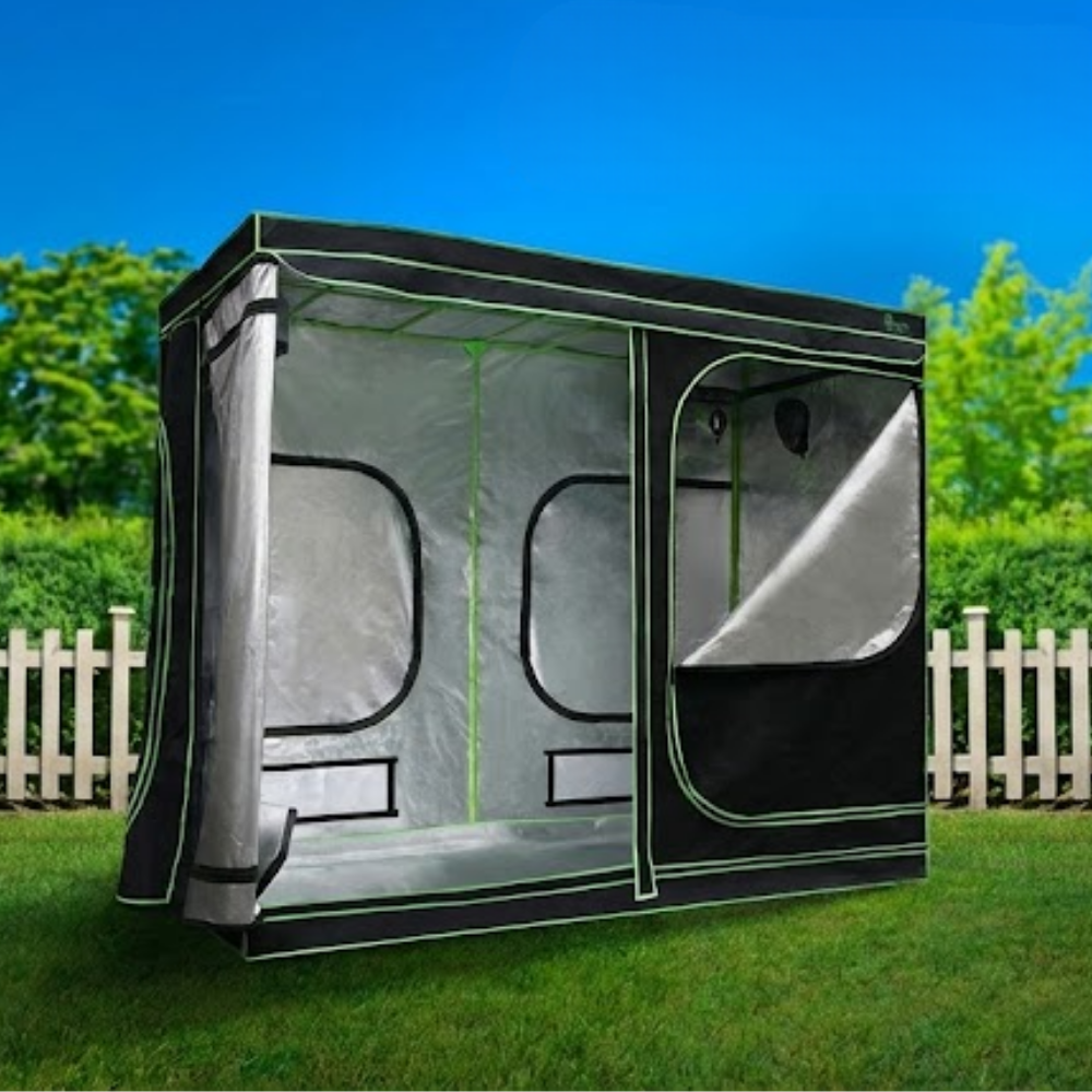 Portable screen tent on grass with a blue sky and trees in the background