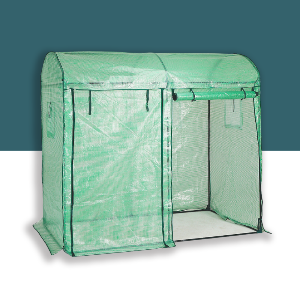 A standalone view of a green dome greenhouse constructed with a durable PE cover. The structure features a roll-up zippered door for easy access and side ventilation windows for optimal airflow. The translucent material allows sufficient sunlight for plant growth while offering protection from the elements. The greenhouse is displayed against a clean background to highlight its design and functionality