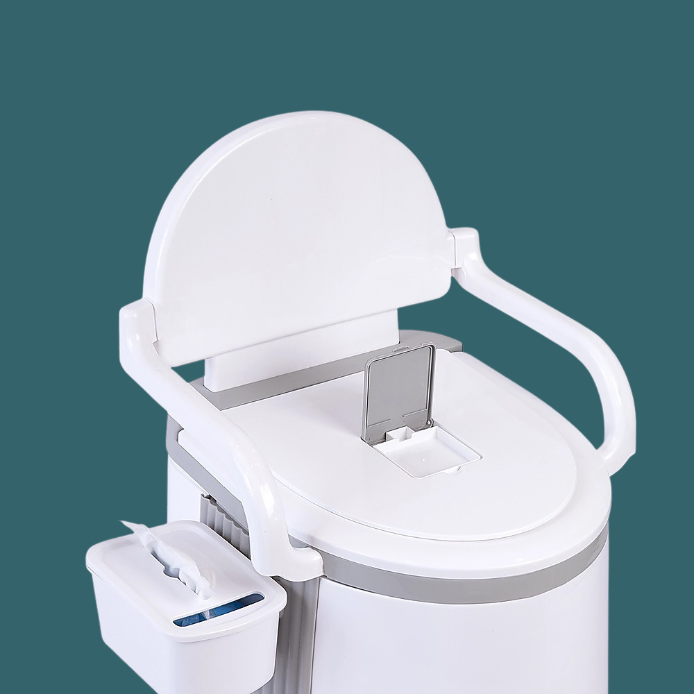 A close-up view against a teal background focusing on the upper portion of the toilet. It details the backrest, the armrests, and the detachable tissue holder/storage bin hanging on the left side.