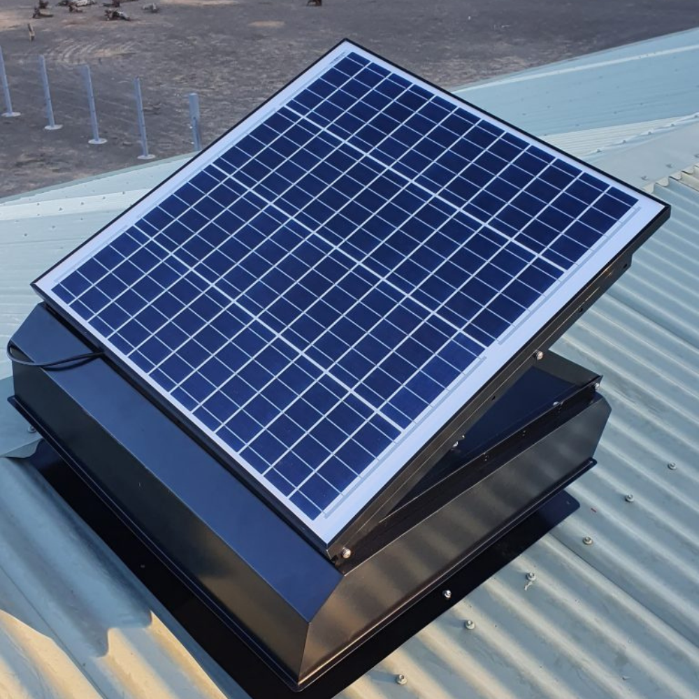 Solar roof ventilator installed on a metal roof, angled solar panel facing the sun.