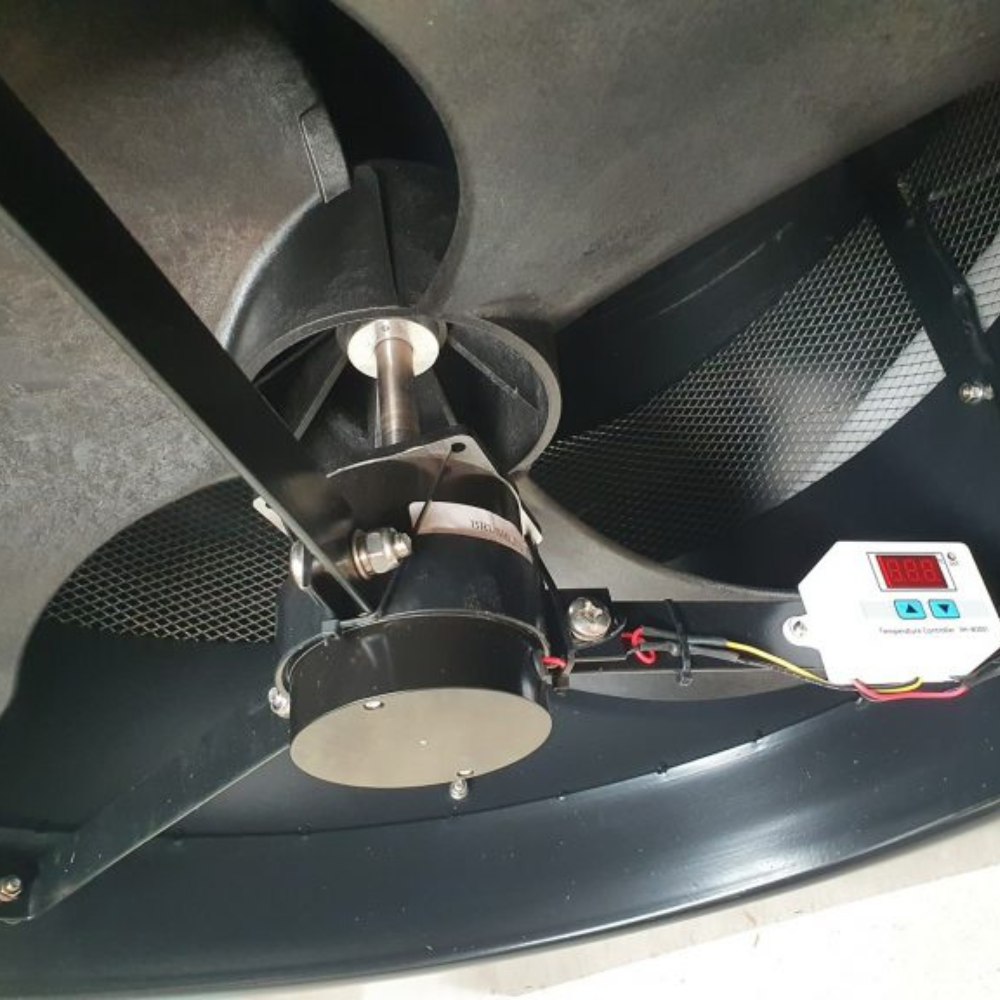 Close-up of an internal fan motor and blades inside a roof ventilator.