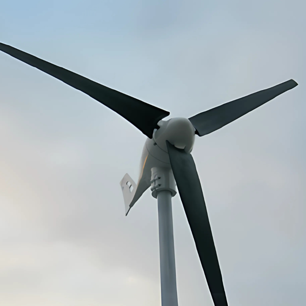 Close-up of a three-blade horizontal-axis wind turbine mounted on a pole, set against a cloudy sky.