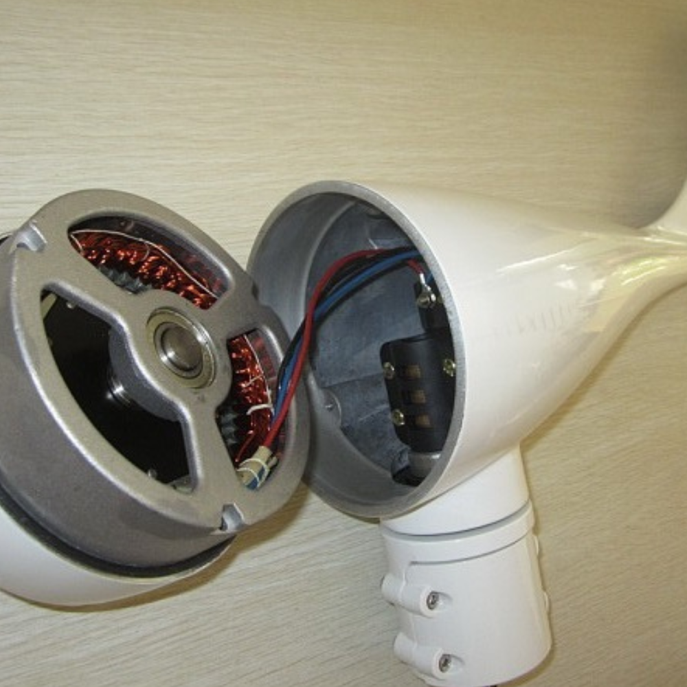 Internal components of a wind turbine showing the stator and wiring inside the turbine housing.