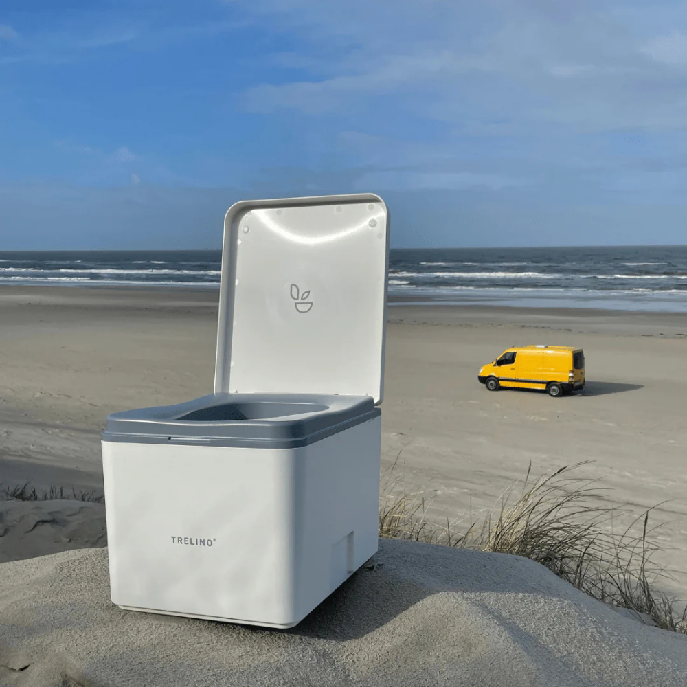 Trelino® Evo Portable Composting Toilet on a sandy beach with a yellow van in the background