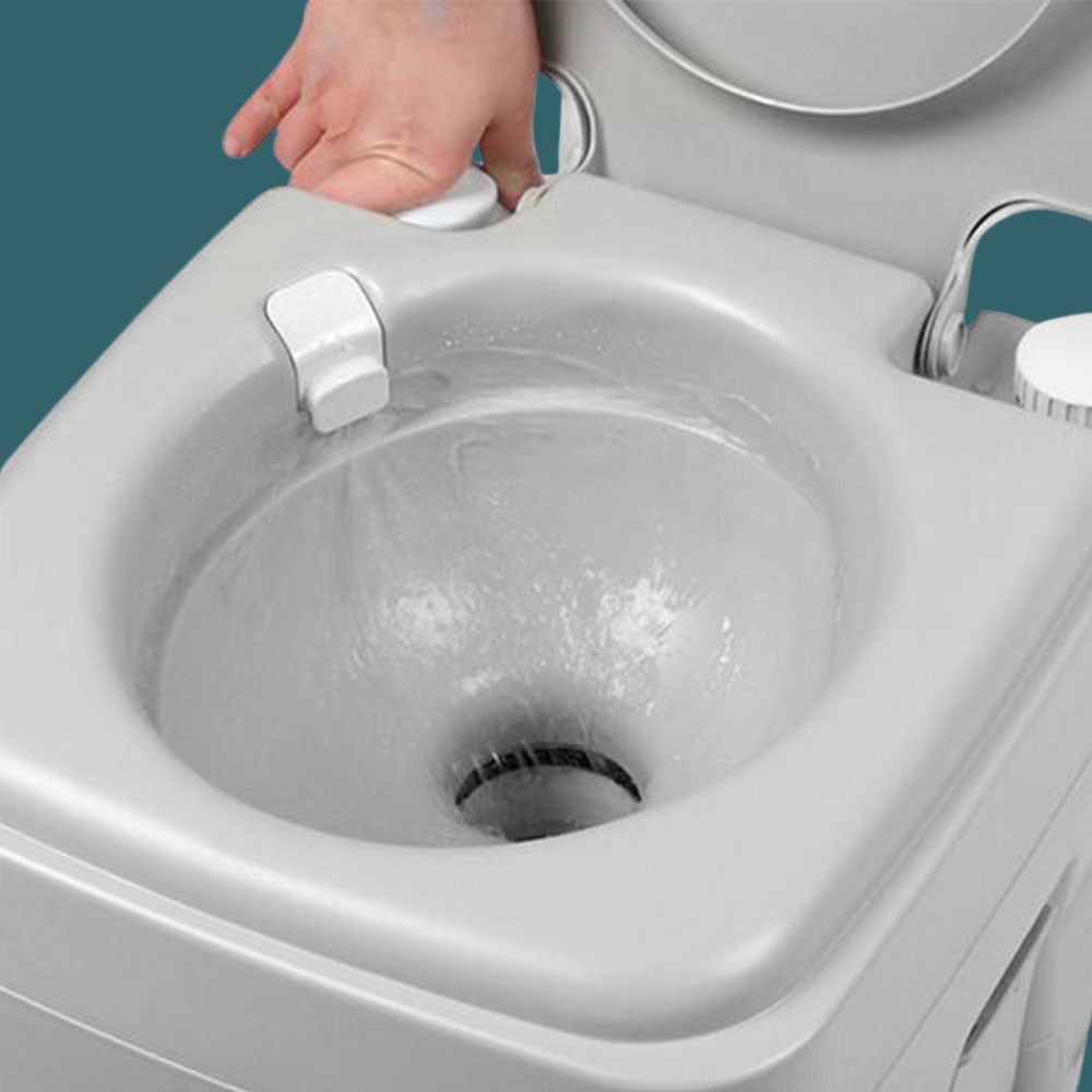 Close-up of flushing action inside a grey portable toilet bowl with hand pulling flush lever.