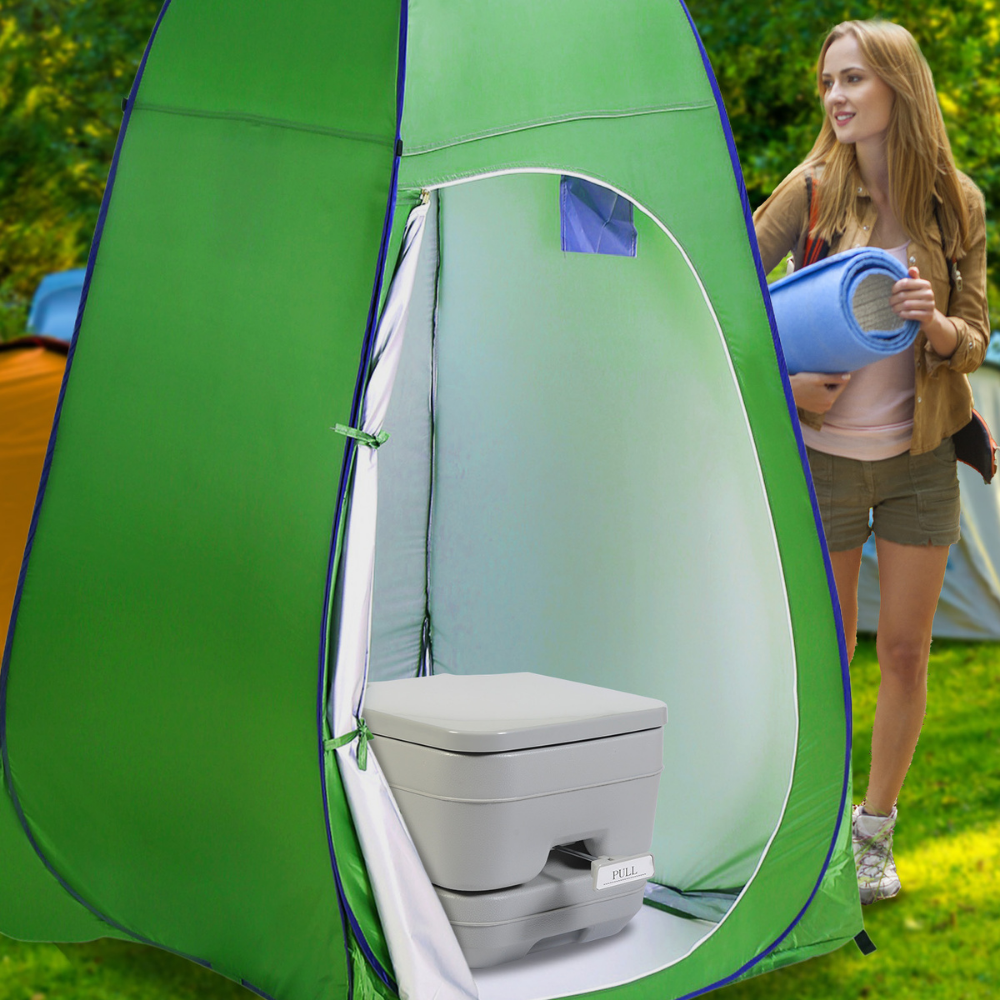 Toilet placed inside a green privacy tent, shown in use during outdoor camping.