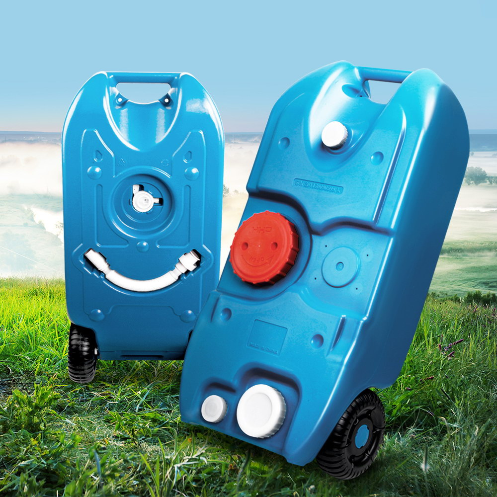 Two blue plastic tanks with wheels on a grassy field with a scenic background.