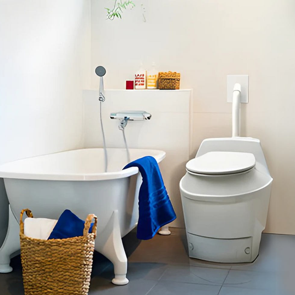 A clean and modern bathroom interior with white and blue accents. The space features a bathtub, a toilet, a sink, and decorative plants, showcasing a refreshing and organized environment.