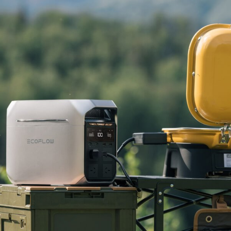 EcoFlow power station on a camping setup with a yellow container in the background.
