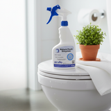 Ecoflo Nature Flush Enzymes 750ml spray bottle on a toilet lid with potted plant, designed for odour control and cleaning.