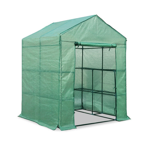 Another view of the same greenhouse, fully closed, with the green covering entirely enclosing the structure.