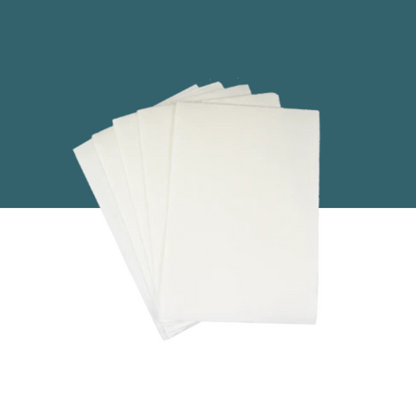 Separett Tiny® absorb pads shown in a fanned-out stack against a teal and white split background.