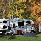Motorhome parked in a forest with autumn foliage