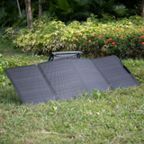 Foldable solar panel on grass with greenery in the background