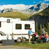 Family at a campsite with an RV in a mountainous area