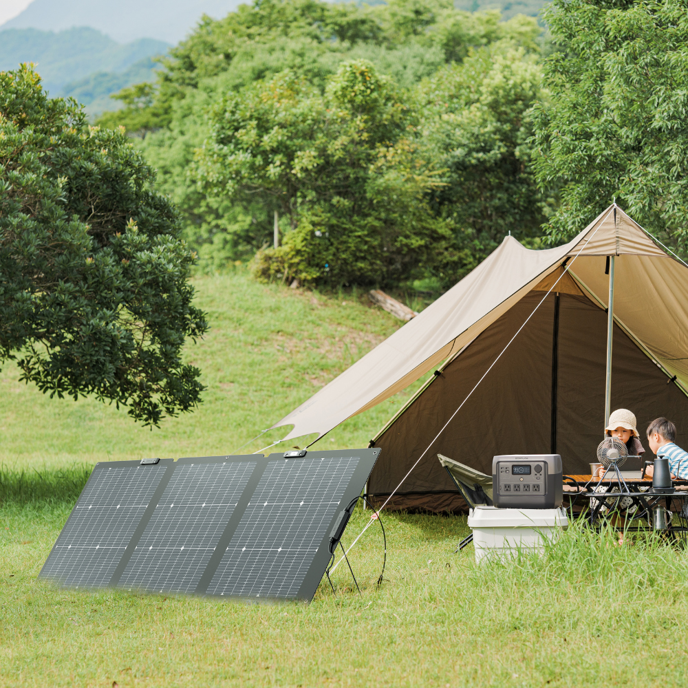 Camping scene with a tent, solar panel, and generator in a green outdoor setting.