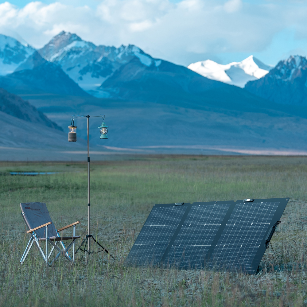 Solar panel and chair in a field with mountains in the background