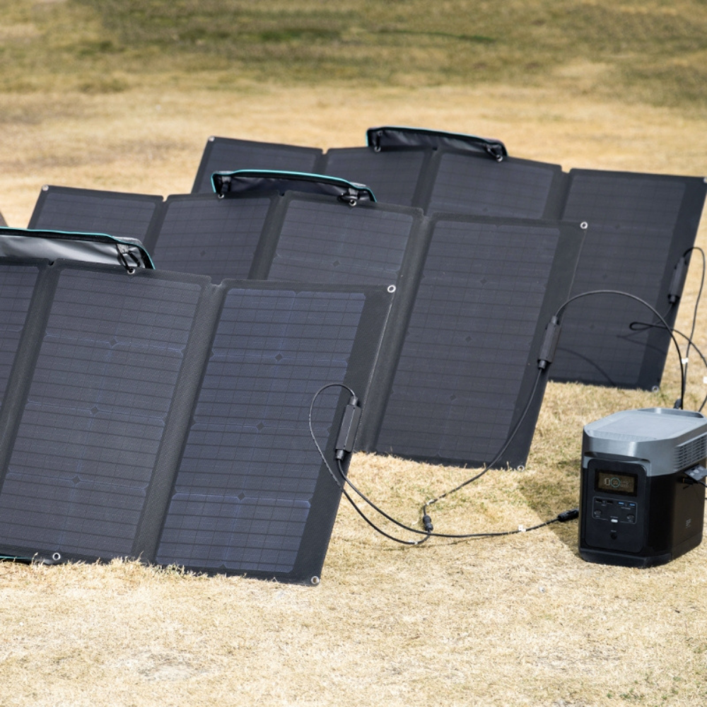 Set of solar panels on a grassy field with a power station.