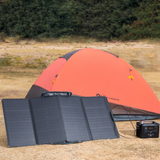 Solar panel and power station in front of a tent in a camping setting