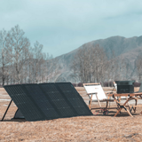 Solar panels in an outdoor setting with mountains and trees in the background
