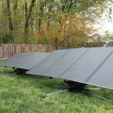 Solar panels on a grassy area with trees in the background