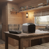 Vintage-style interior with a wooden table, books, and a lamp.