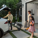 Family with luggage getting into a car outside a modern house with ecoflow delta pro ultra trolley 