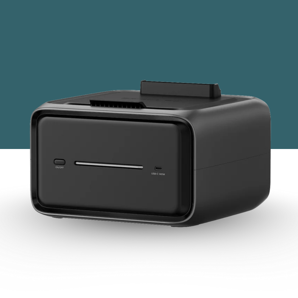 Black electronic device on a white surface with a teal background