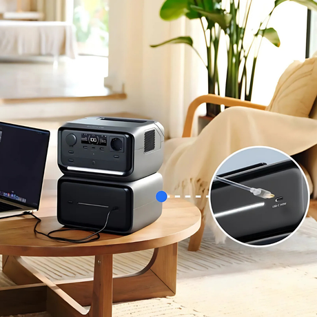Portable power station on a table with a laptop, surrounded by a cozy living room setting.