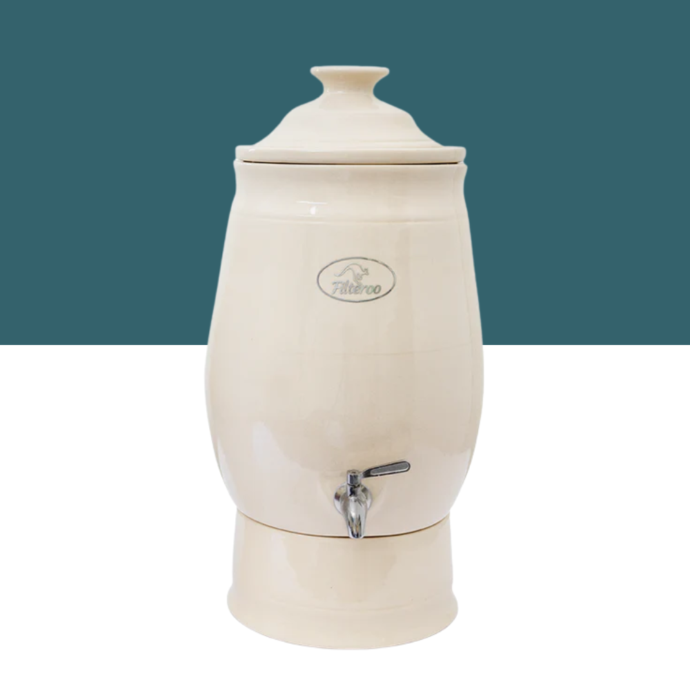 Beige ceramic water dispenser with a lid on a white background