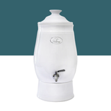 White ceramic water dispenser with a silver faucet on a white background