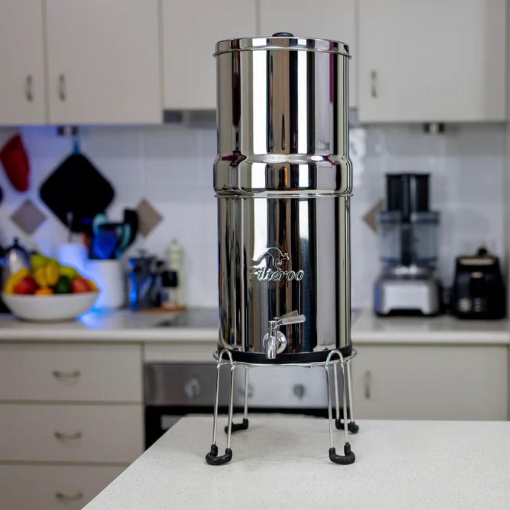 Stainless steel water filter on a kitchen counter with blurred background