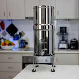 Stainless steel water filter on a kitchen counter with blurred background