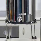 Metal water filter on a stand with a blurred background