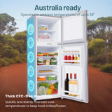 Refrigerator with open doors showing food items in a natural setting with trees and a clear sky.